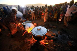 Ethiopian refugees fleeing from the ongoing fighting in Tigray region, wait for food at the Um-Rakoba camp, on the Sudan-Ethiopia border, in the Al-Qadarif state
