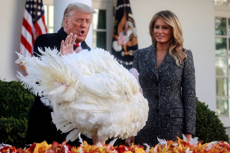 O presidente Donald Trump, ao lado da primeira-dama Melania Trump, perdoa o peru batizado de Corn às vésperas do Dia de Ação de Graças