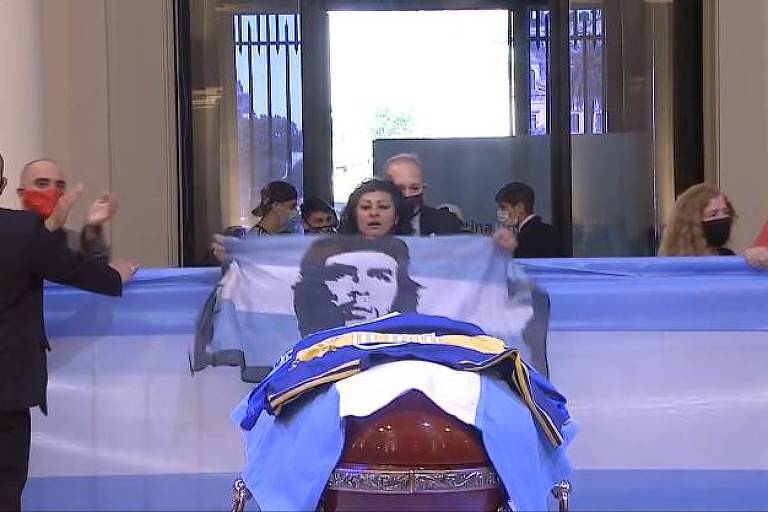 Mulher exibe bandeira da Argentina com o rosto de Che Guevara durante velório de Maradona