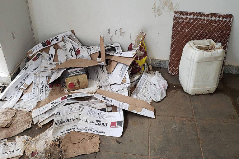 Relatório fotográfico das condições de alojamento dos operários da empresa Shox do Brasil Construções LTDA na foto hall de acesso ao alojamento: ausência de limpeza e muito lixo espalhado pelo local