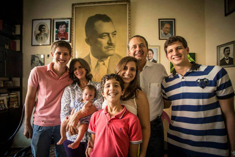 Eduardo e Renata Campos, com Miguel no colo, posam como retrato de Arraes ao fundo, ao lado dos outros filhos: Pedro, José, Maria Eduarda e João