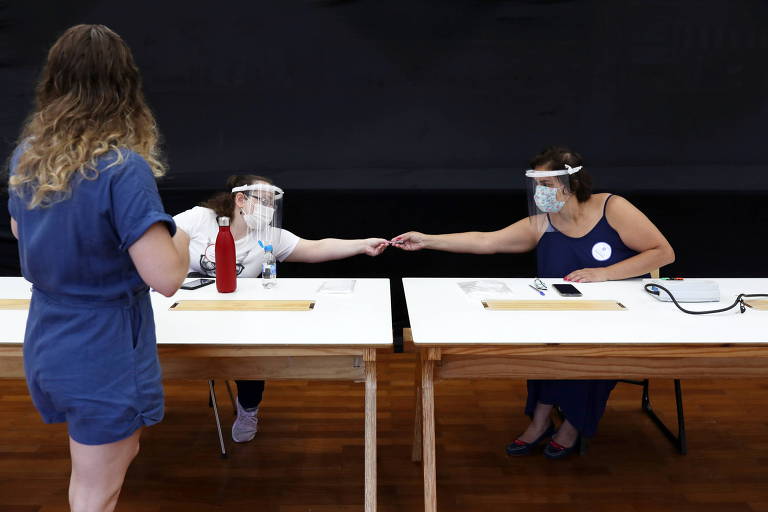 Trabalhadores eleitorais usam máscaras em uma seção eleitoral durante as eleições municipais em São Paulo, Brasil