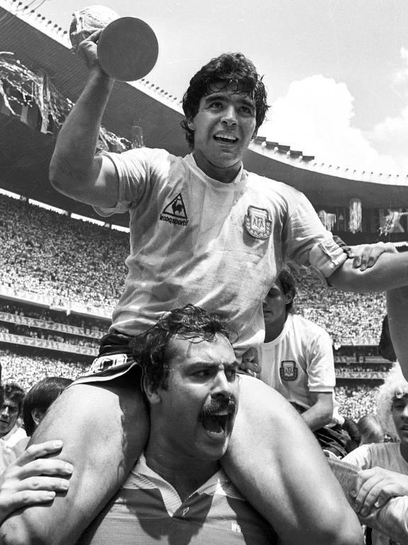 Maradona é carregado por Cejas com a taça da Copa de 1986