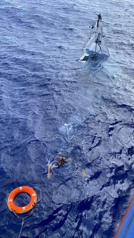 Homem nada em direção a uma boia após ser encontrado agarrado a barco naufragado
