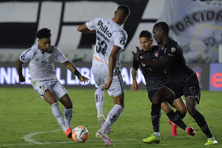 Os santistas Marinho (à esq.) e Bruninho tentam superar a defesa da LDU na derrota do Peixe por 1 a 0, na Vila Belmiro