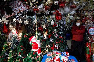 FILE PHOTO: A shopkeeper waits for customers next to Christmas decorations at a traditional market amid the coronavirus disease (COVID-19) pandemic in Seoul