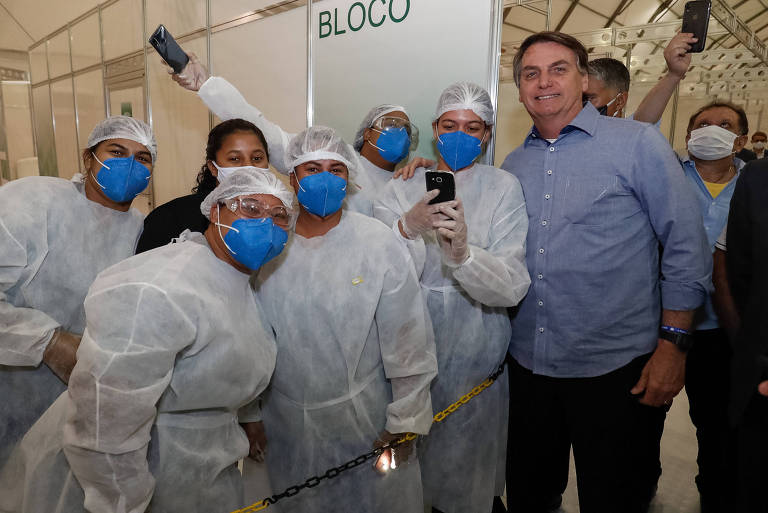Jair Bolsonaro visita hospital de campanha inaugurado durante pandemia, em Goiás, e posa para foto com equipe hospitalar
