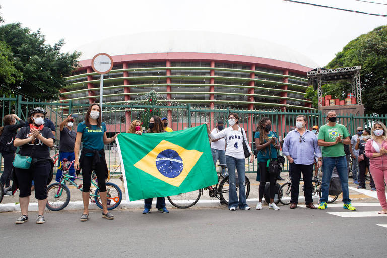 As ex-atletas Maurren Maggi e Vera Mossa seguram a bandeira do Brasil durante protesto
