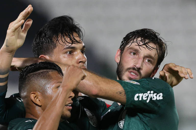 O zagueiro Gustavo Gómez (centro) comemora seu gol contra com Roni (esq.) e Viña, no estádio Defensores Del Chaco, em Assunção (PAR)
