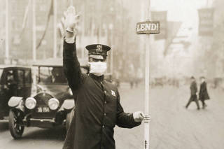 In a photo provided by the National Archives, a police officer directs traffic while wearing a mask during the 1918 flu pandemic.  (National Archives via The New York Times)