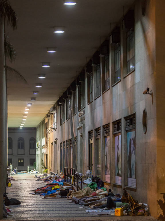 Moradores de rua sob marquise no centro do Rio de Janeiro.