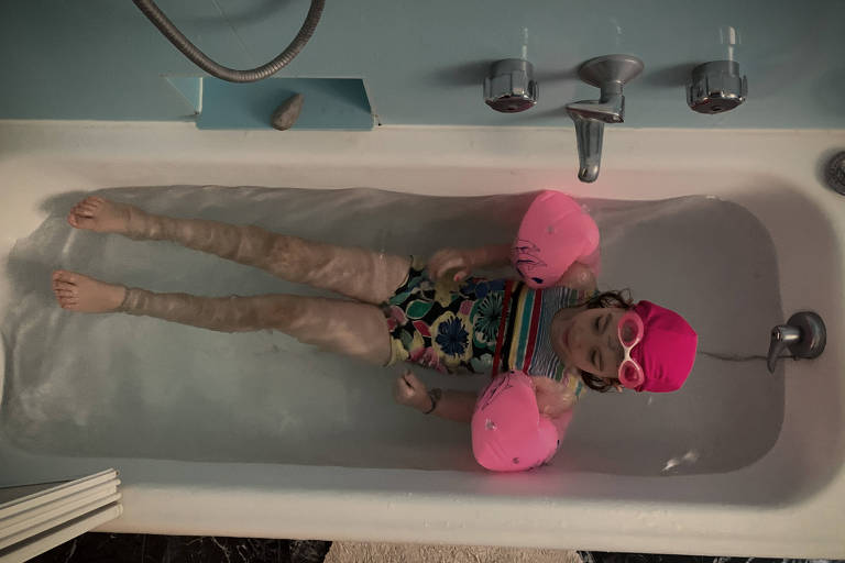 Rosa, 6, na banheira de casa, em Milão