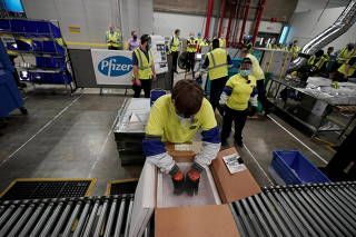 Boxes containing the Pfizer-BioNTech COVID-19 vaccine are prepared to be shipped at the Pfizer Global Supply Kalamazoo manufacturing plant in Portage