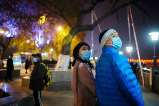 Duan Ling and her husband Fang Yushun walk on a street, almost a year after the global outbreak of the coronavirus disease (COVID-19) in Wuhan