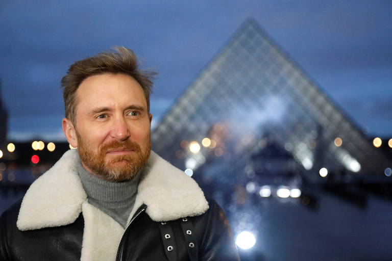 O DJ francês David Guetta em frente à pirâmide do Louvre 