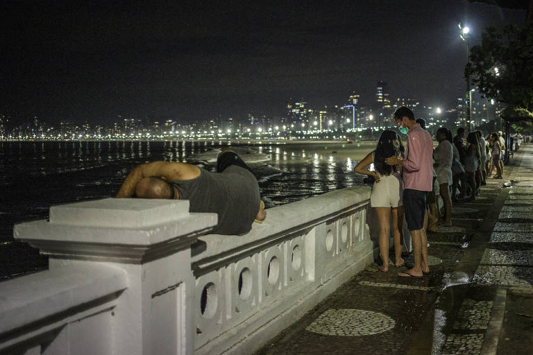Pessoas na orla de Santos, que proibiu acesso para a comemoração da virada do ano na areia da praia 