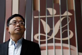 FILE PHOTO: Pro-democracy lawmaker James To poses in front of the Legislative Council logo inside the council building in Hong Kong