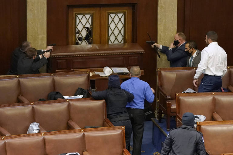 Polícia do Capitólio aponta armas para entrada do plenário da Câmara, na tentativa de conter apoiadores de Trump