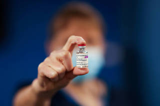 FILE PHOTO: A healthcare worker holds a vial of the AstraZeneca/Oxford University COVID-19 vaccine at the Pentland Medical Practice in Currie, Scotland