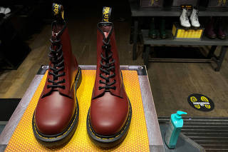 FILE PHOTO: A pair of Dr. Martens boots is seen through the window of a Dr Martens store in London