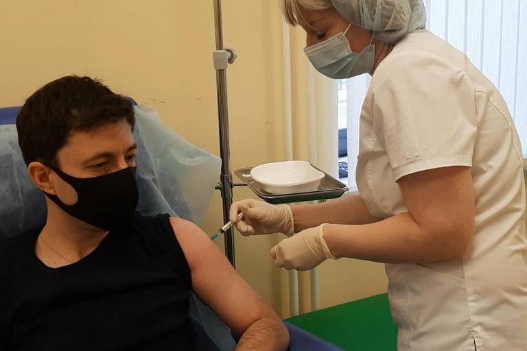 O jornalista brasileiro Fábio Aleixo recebe a primeira dose da vacina Sputnik V em Moscou