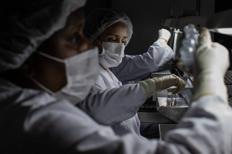 Funcionárias trabalham na inspeção visual da linha de produção de doses da vacina Coronavac, contra a Covid-19, no Instituto Butantan, em São Paulo