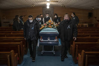 Pall bearers with the coffin of Jesse Taken Alive, a Lakota member of the Standing Rock Tribe who died of COVID-19, at Kesling Funeral Home in Mobridge, S.D., on Dec. 26, 2020.  (Victor J. Blue/The New York Times)