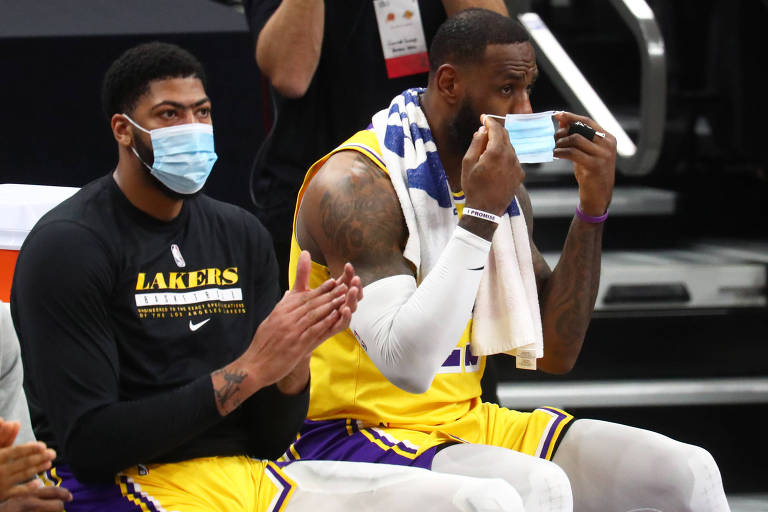 LeBron James (à dir.), do Los Angeles Lakers, coloca a máscara ao lado do companheiro Anthony Davis em partida da NBA