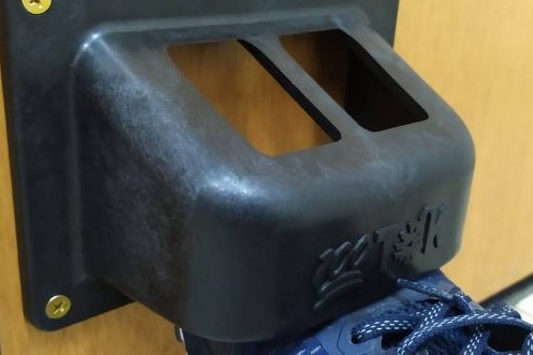 Dispositivo 100Tok que permite abrir portas com os pés; produto é feito com polipropileno, tipo de plástico, e custa R$ 25