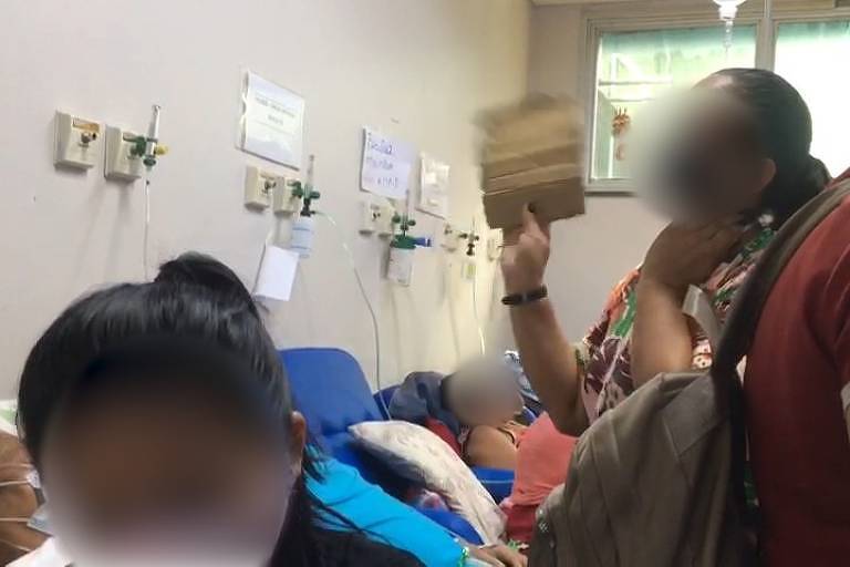 Mulher abana com papelão parente internada com Covid-19 em hospital de Manaus