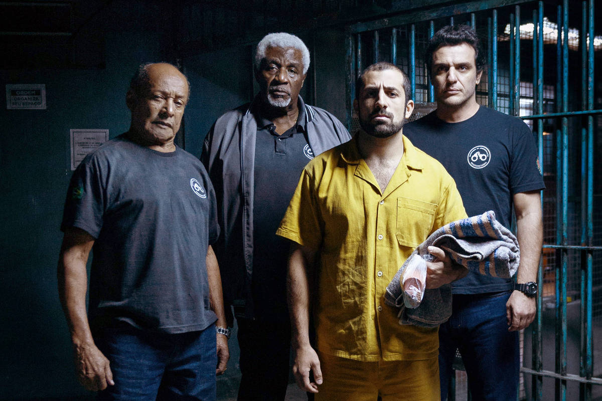 Cap 1 Cena 24D ? Noite ? corredor ? acesso raios ? Adriano ( Rodrigo Lombardi ) e Valdir ( Tony Tornado ) levam Abdel ( Kaysar Dadour ) pra cela. Cabelo ( Germano Pereira) e detentos ameaçam o terrorista. Juarez ( Romulo Braga ) vê. Bastidores