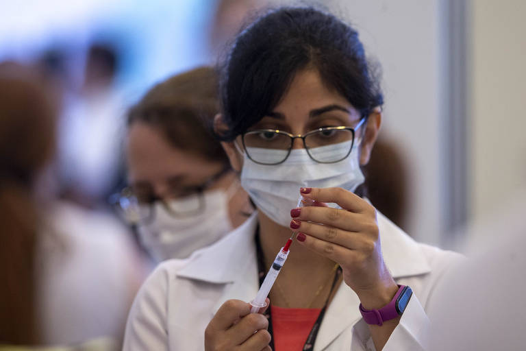 Profissional manipula dose da Coronavac