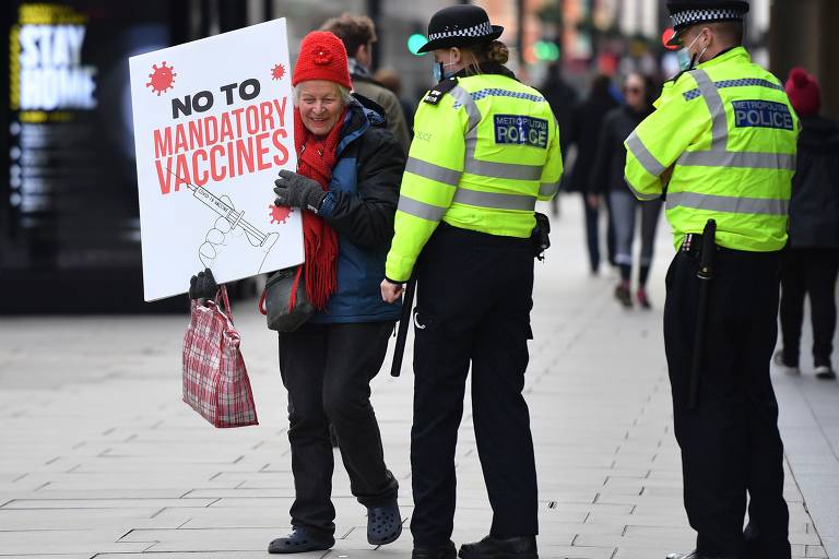 Mulher protesta contra vacinas obrigatórias em frente à fundação Bill e Melinda Gates, em Londres
