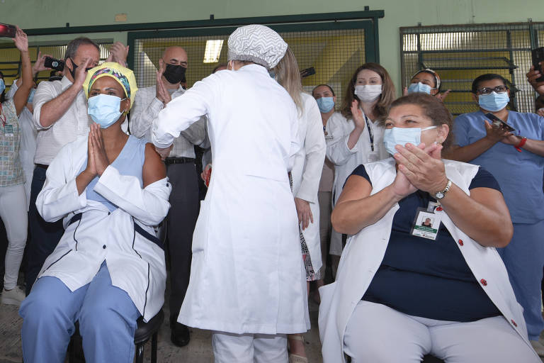 As enfermeiras Helen Pacheco (esq.) e Eliana Quiaratti recebem dose de Coronavac em Hospital de Pirituba, zona norte de SP