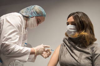 A woman receives an injection with Sputnik V (Gam-COVID-Vac) vaccine against the coronavirus disease (COVID-19) in Moscow