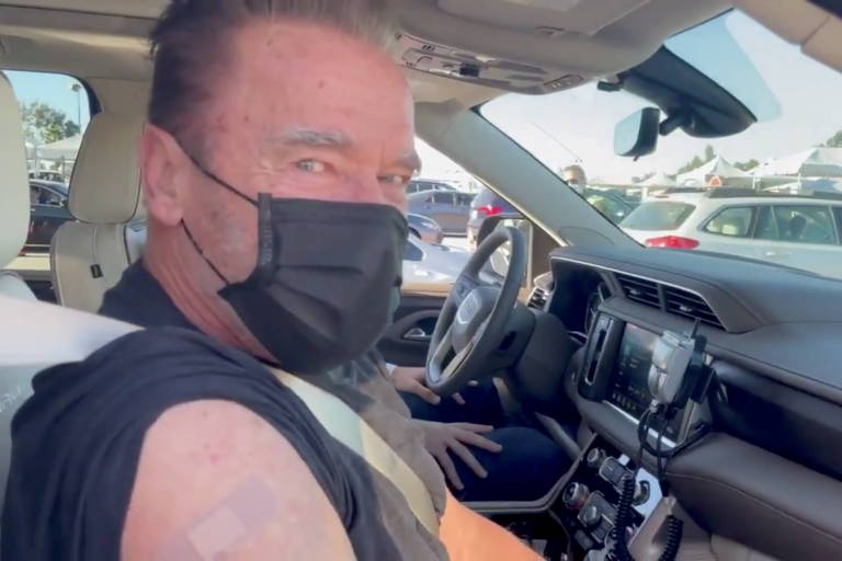 O ex-governador da Califórnia Arnold Schwarzenegger está utilizando uma máscara preta após receber a vacina contra o coronavírus no estádio Dodger Stadium, em Los Angeles, Estados Unidos.
