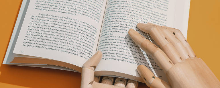 Mãos de madeira seguram livro aberto (fundo amarelo)