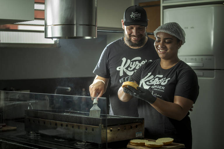 O casal  Wilson Roberto de Freitas Junior, 36, e Bruna Lima dos Santos de Freitas, 31, prepara hambúrgueres em sua hamburgueria, a Kyro's, sediada em sua própria casa, em Itaquera, na zona leste de São Paulo