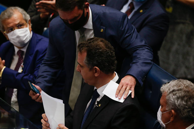 O senador Flávio Bolsonaro (Republicanos-RJ) passa o celular para Pachecho, eleito presidente da Casa
