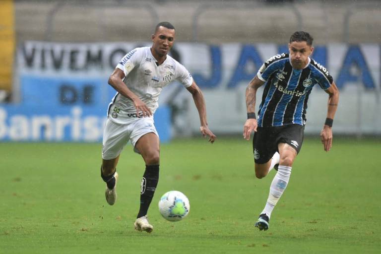 Lucas Braga (à esq.) disputa a bola durante partida entre Santos e Grêmio pelo Campeonato Brasileiro