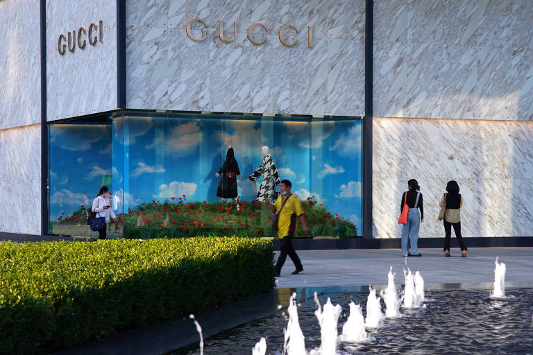 Pessoas passam por uma loja da marca italiana de luxo Gucci em um complexo comercial em Pequim
