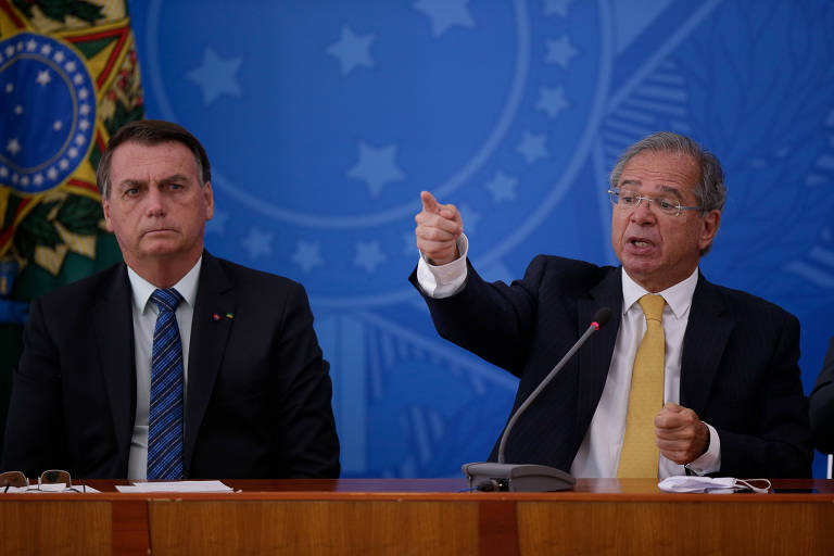O ministro da Economia, Paulo Guedes, ao lado de Jair Bolsonaro durante entrevista coletiva
