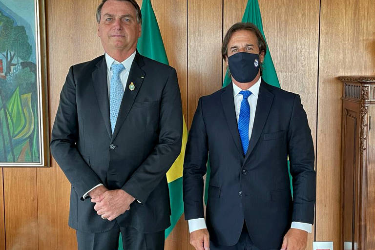 Os presidentes do Brasil, Jair Bolsonaro, e Luis Lacalle Pou (usando máscara), do Uruguai, em encontro no Palácio do Planalto, em Brasília