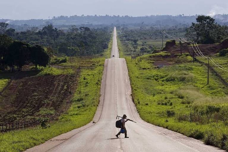 Homem aparece atravessando estrada, que continua até o fim da imagem