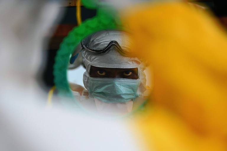 Nesta foto tirada em 15 de agosto de 2014, um médico do Médicos Sem Fronteiras (MSF) confere seu equipamento de proteção individual em uma unidade do MSF em Kailahun, epicentro do pior surto de Ebola no mundo.