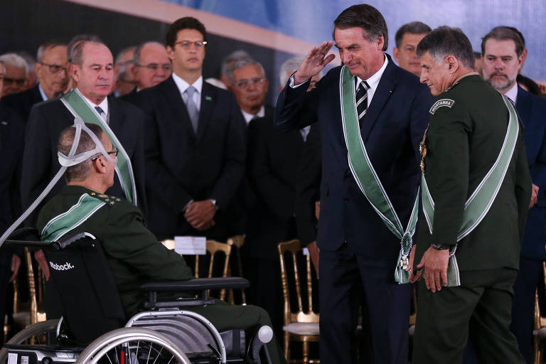 Bolsonaro, ladeado por Pujol (dir.) e Azevedo (esq.), todos com faixa verde, presta continência a Villas Bôas na sua despedida do Comando do Exército
