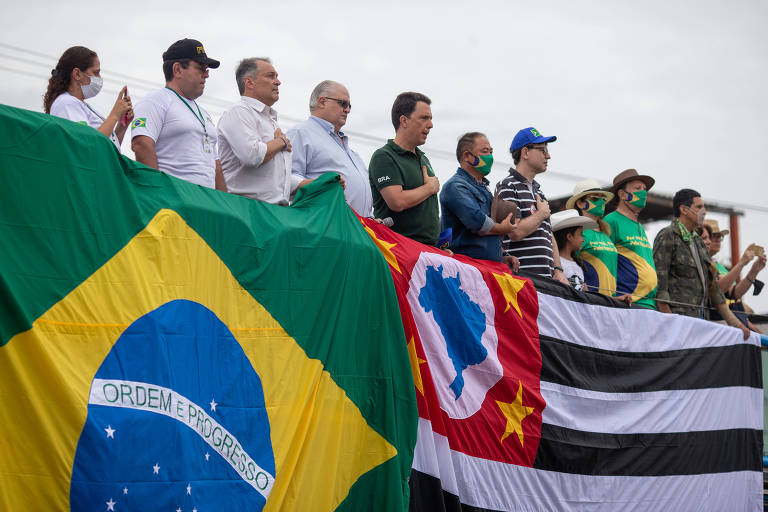 Manifestantes em um carro de som cantam o hino nacional antes do início do tratoraço em frente à Ceagesp, na zona oeste de São Paulo