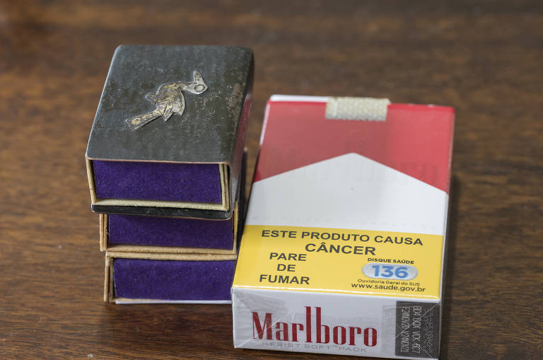 Caixinhas de fósforo personalizadas e maço de cigarros para o escritor, que segue fumante