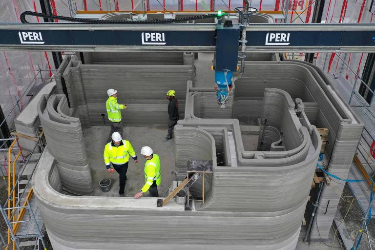 Operários acompanham construção de edifício residencial com impressora 3D na Alemanha