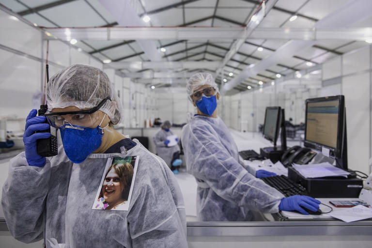 A enfermeira Adriana Lario se comunica com suas colegas em uma das alas do hospital de campanha do Pacaembu em Sao Paulo